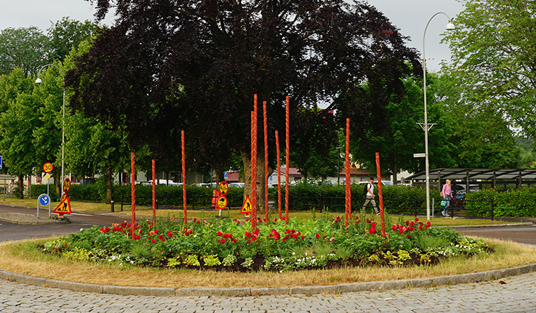 Borgmästarrondellen med röda blommor och pelare för klätterväxter.