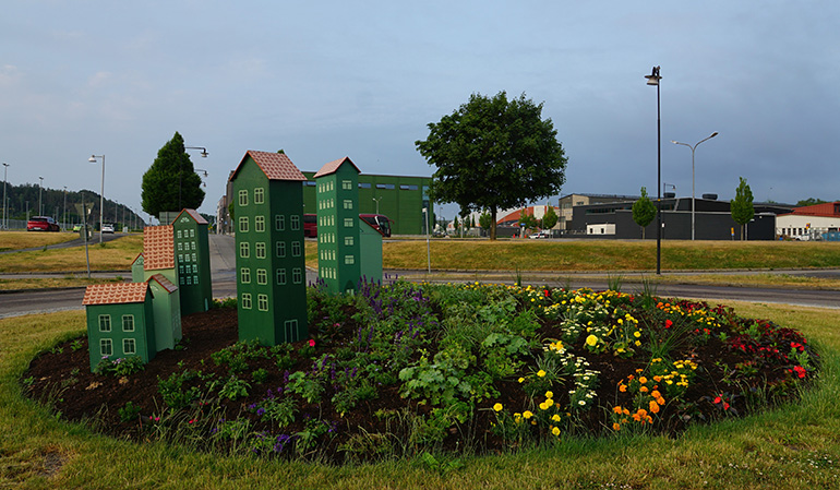 Rondellen i Söderstaden, rondellen är fylld med miniatyrer av gröna hus och blommorna är planterade i regnbågens färger.