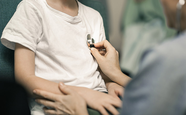Ett stetoskop mot ett barns hjärta.