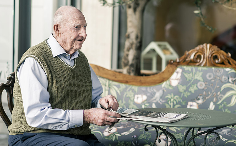 En äldre man läser en tidning