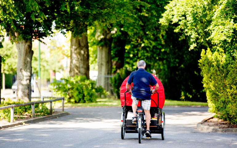 En man som cyklar med ett äldre par