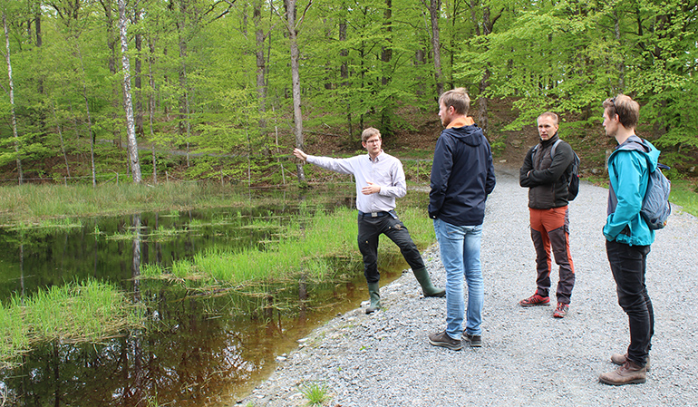 Thomas Axelson från Skogssällskapet visar den återställda våtmarken i Stättared för John Borlid, Andres Lund och Mårten Västerdal.