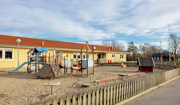 Dannebackens förskolegård med rutschkana och sandlåda.