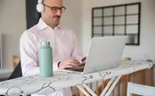 Person skriver på en dator i hemmamiljö.
