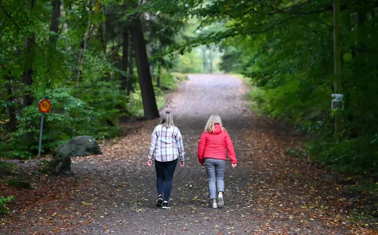 Två personer som promenerar i en skog.