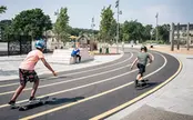 Barn åker skatebord i en park